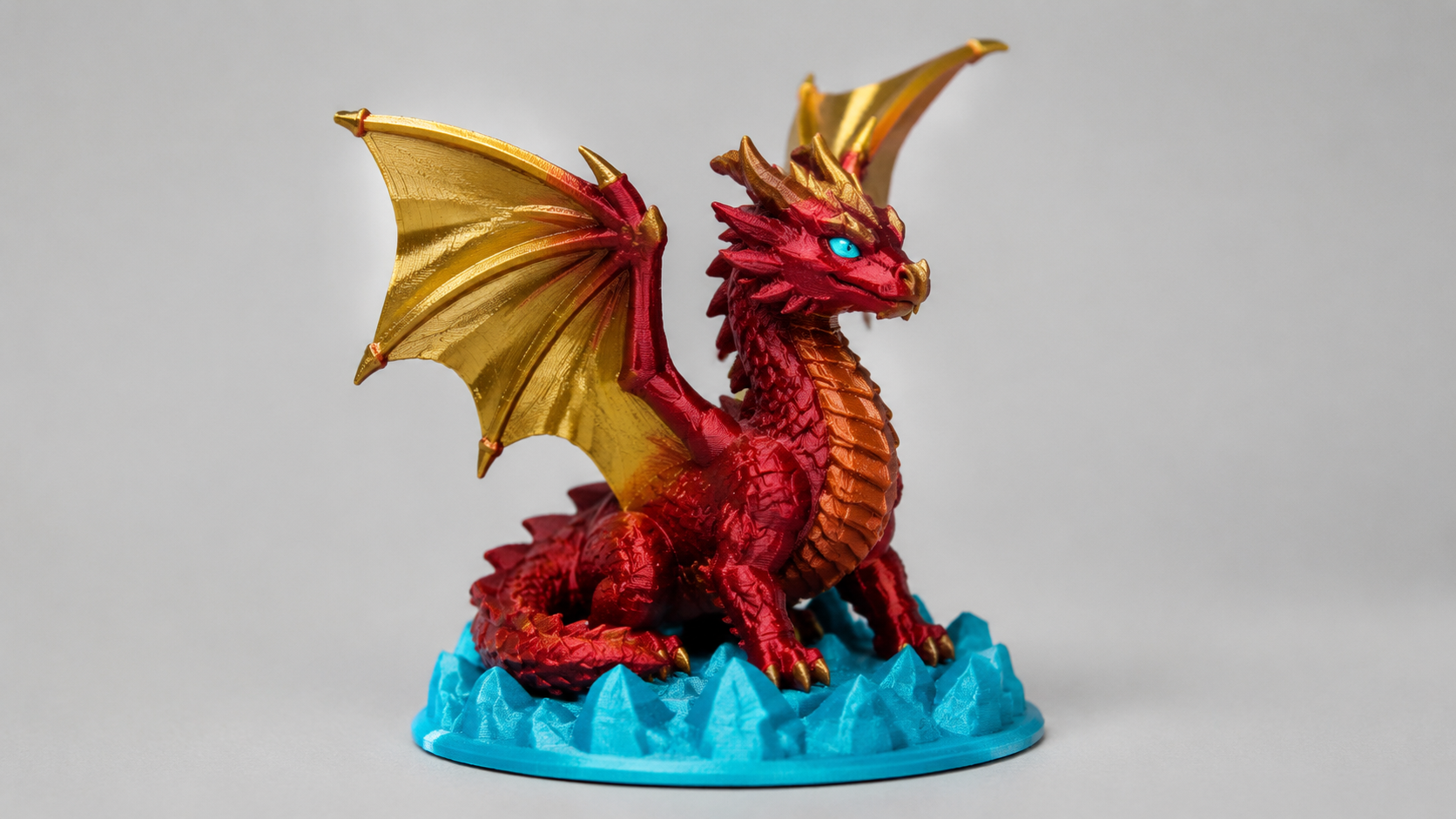 A small multicolor 3D printed creature statue with distinct color zones in a clean studio light
